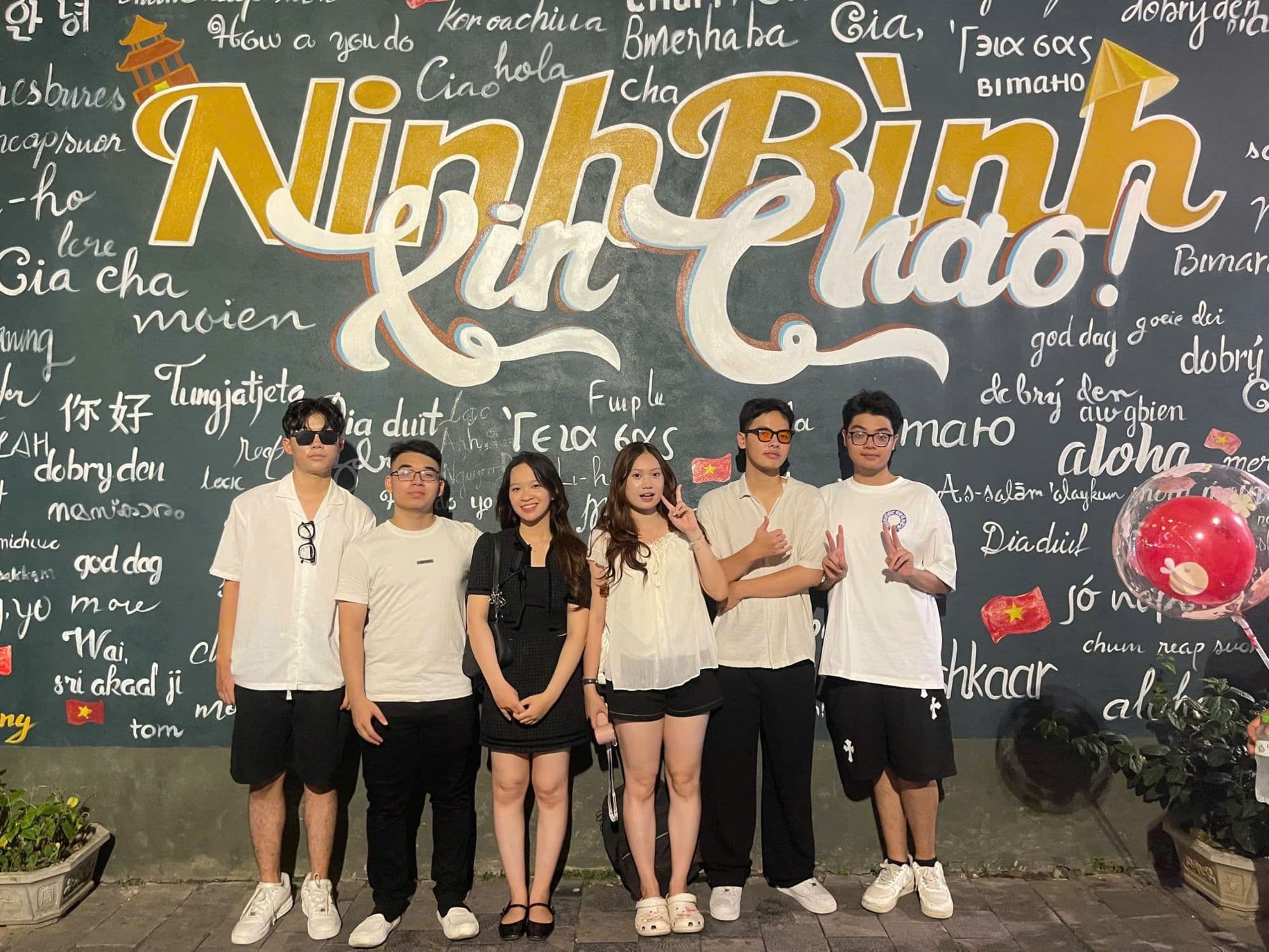 The crew in front of the “Ninh Bình xin chào!” wall